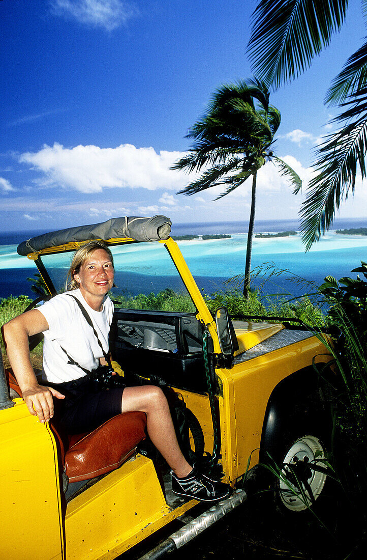 Tourist in a yellow jeep. Bora-Bora in the Leeward islands. Society archipelago. French Polynesia (model released)