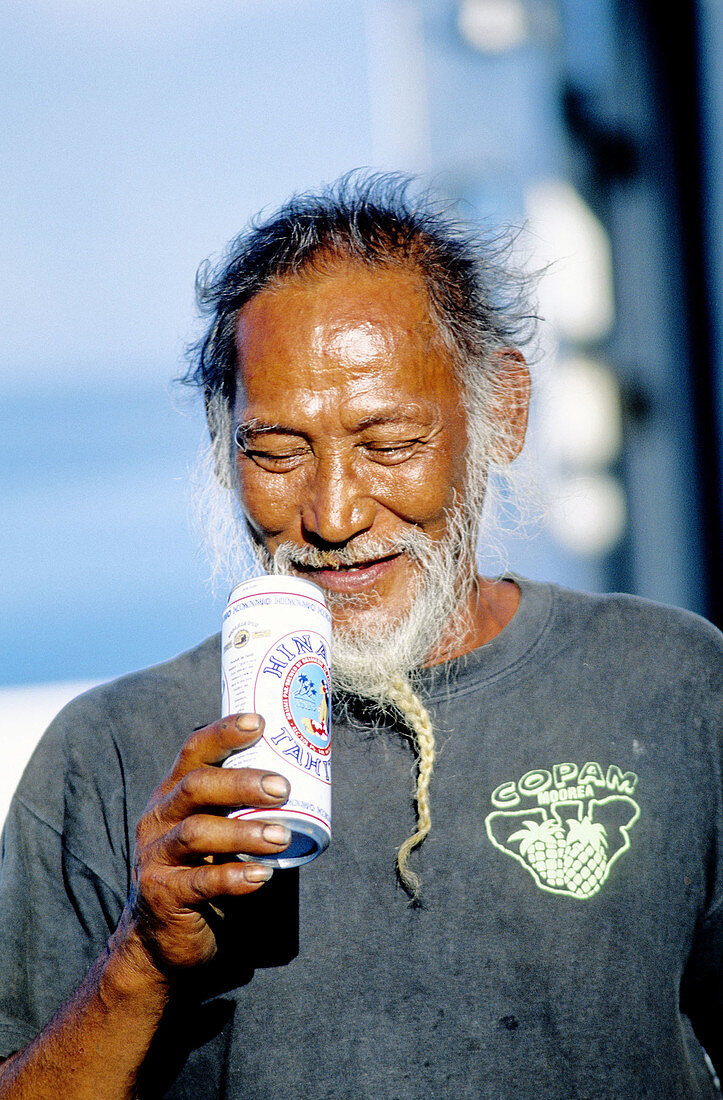 Man drinking local beer Hinano in a can. Tahiti island in the Windward islands. Society archipelago. French Polynesia