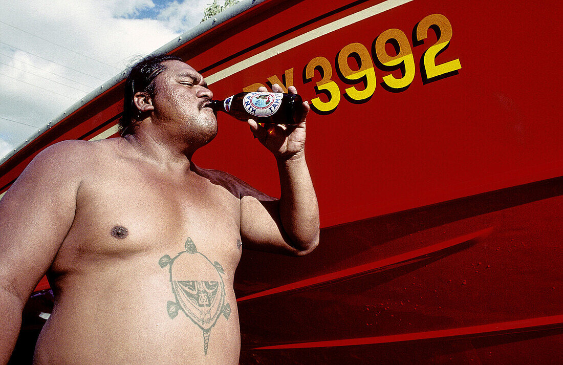 Fisherman having an Hinano beer after returning with his boat (at back)Tahiti island in the Windward islands. Society archipelago. French Polynesia (MR)