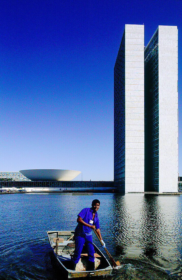  Blue, Blue sky, Boat, Boats, Building, Buildings, Cities, City, Civil architecture, Color, Colour, Contemporary, Daytime, Ethnic, Ethnicity, Exterior, Human, Lake, Lakes, Male, Man, Men, Men only, One, One person, Outdoor, Outdoors, Outside, People, Pers