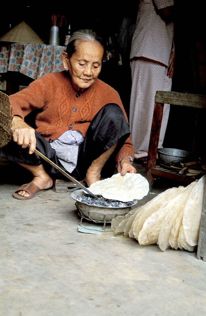 Woman baking traditional rice bread. Hoi An. Vietnam