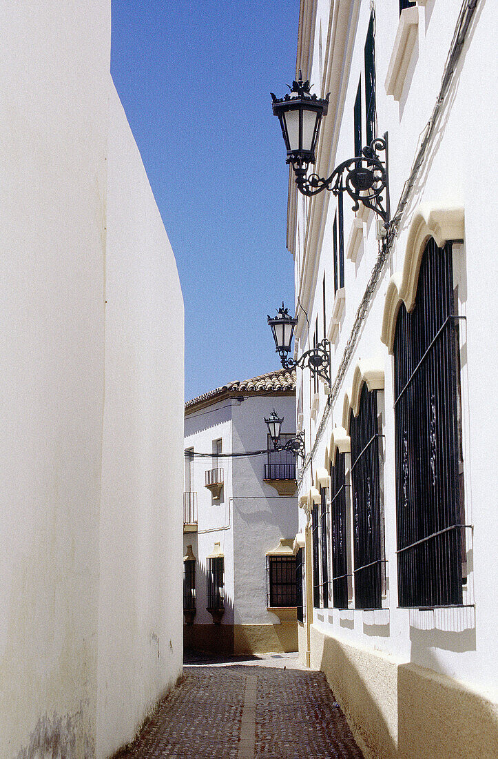 Typical narrow lane lined with white washed walls. Ronda, Málaga province. Spain