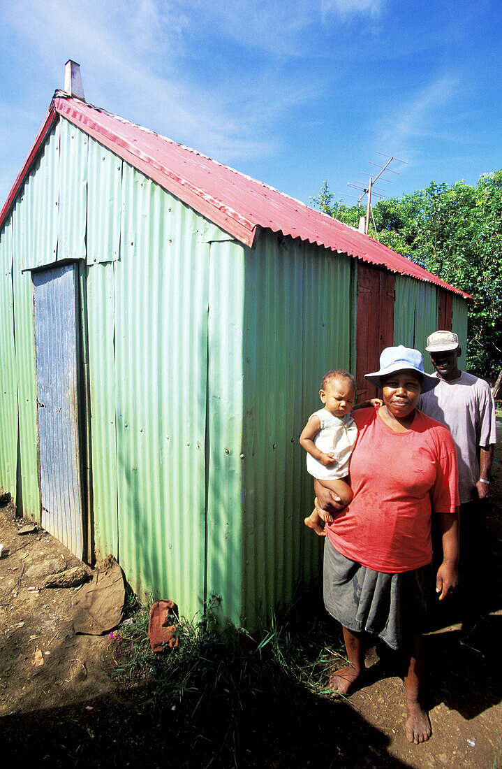 Family in local hut (walls and roof are made of corrugated iron). Rodrigues Island. Mauritius