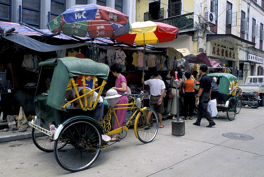 Commercial street and rickshaws. Macau, China