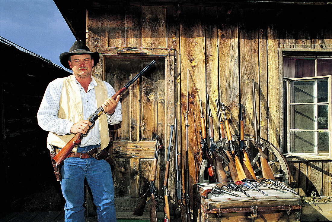 Cowboy showing his collection of guns. M Lazy C Ranch, Colorado. USA