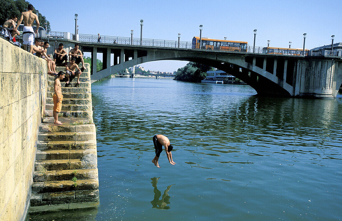 Young people diving in Guadalquivir river. Sevilla. Spain
