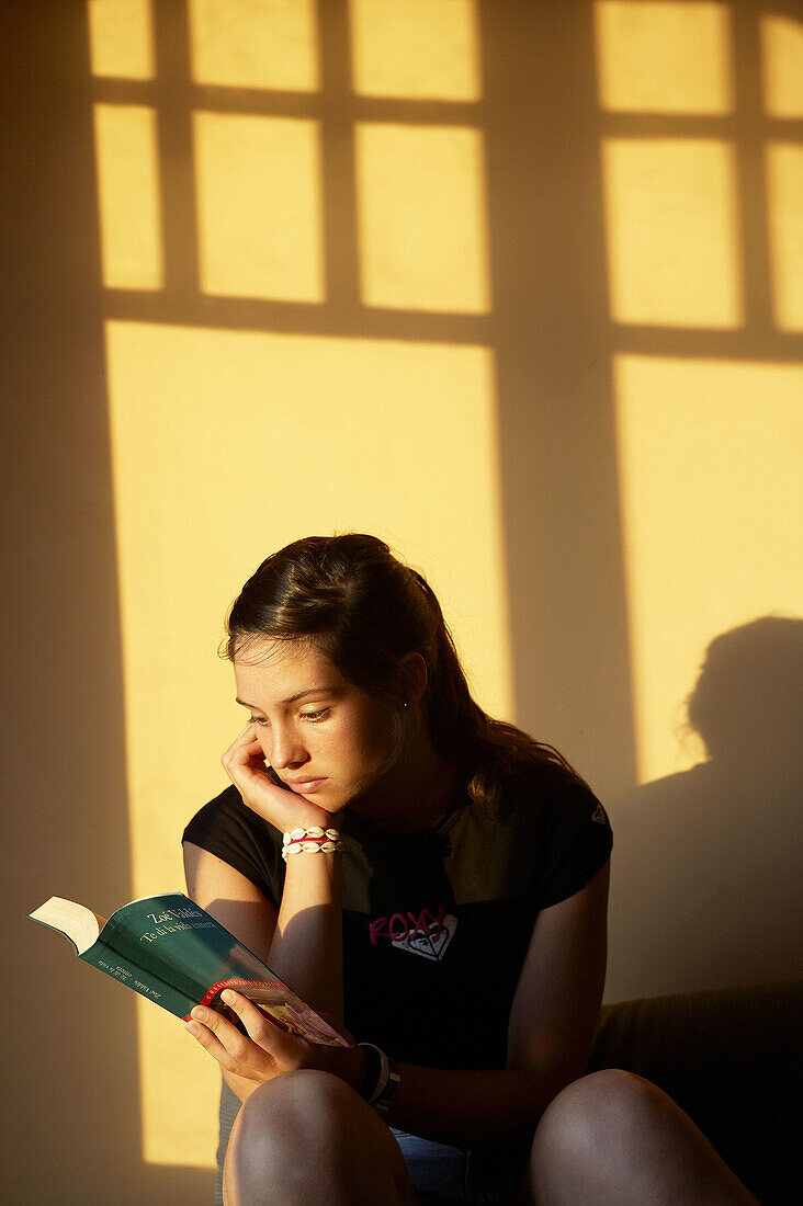 16 years old teenager reading a book.