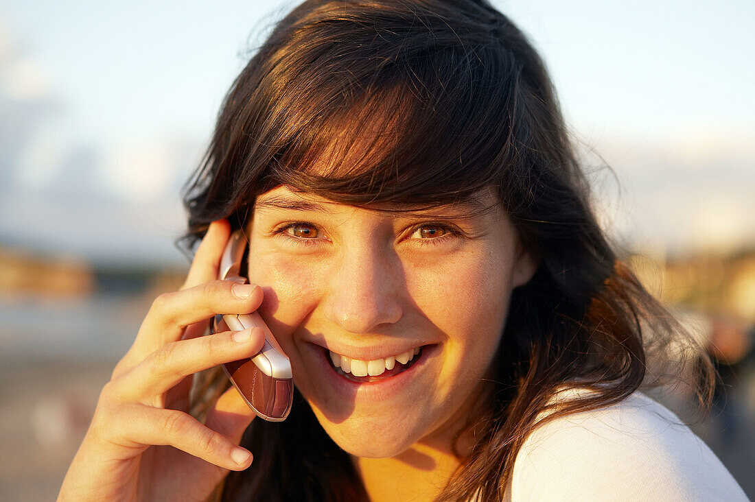 16-jähriger Jugendlicher telefoniert mit einem Handy. Strand von Hendaye. Aquitanien. Frankreich.