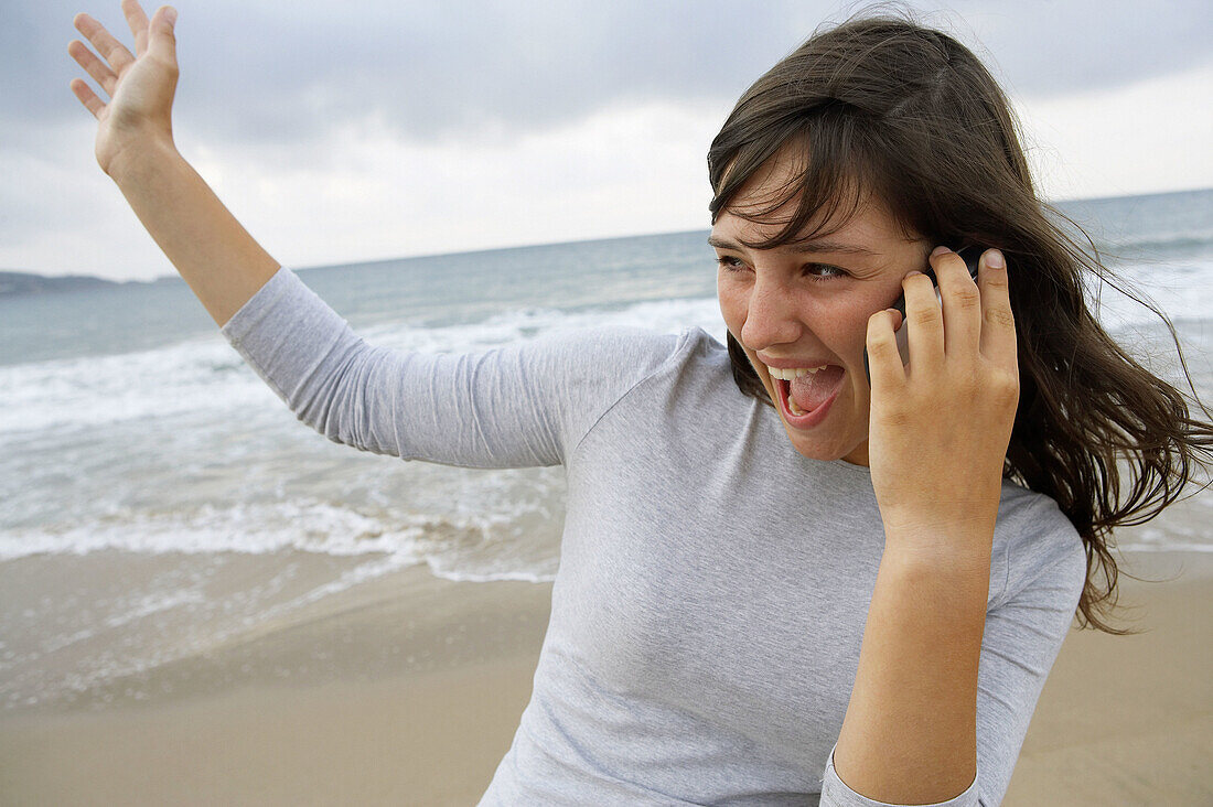 16-jähriges Teenie-Mädchen benutzt Mobiltelefon am Strand