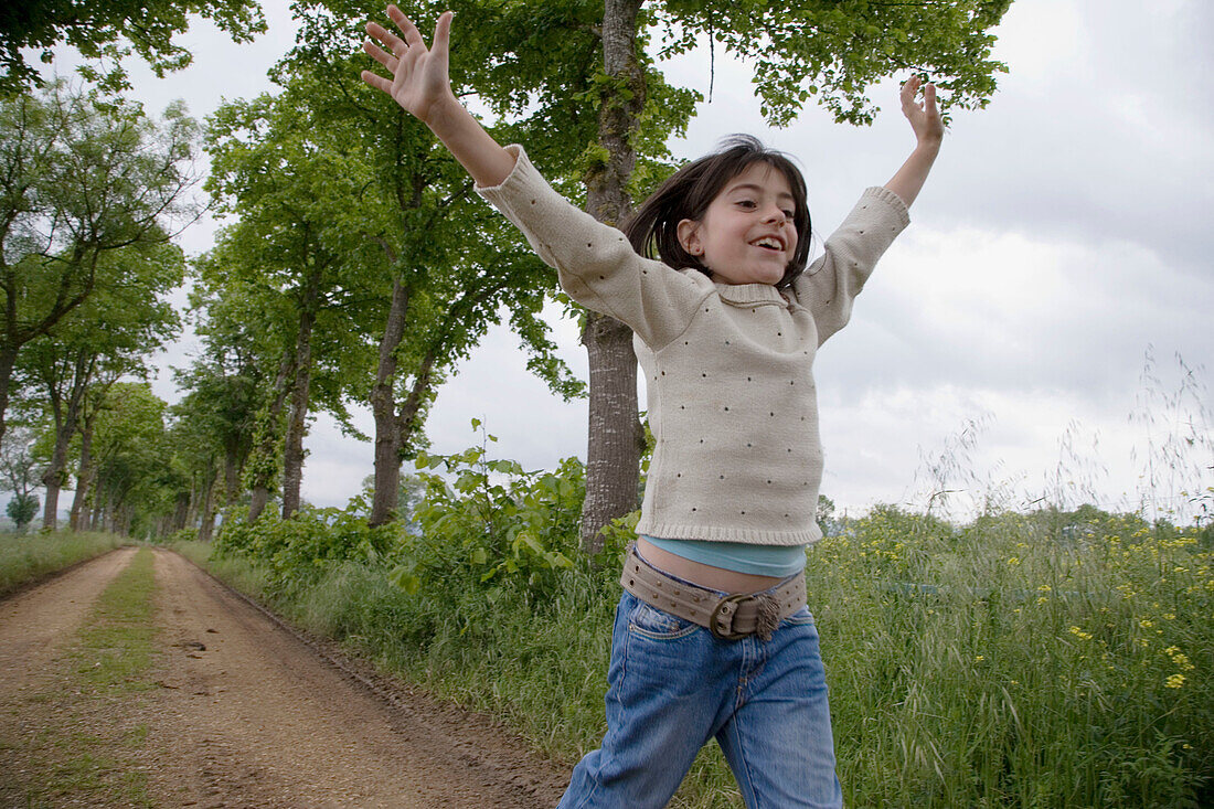 Girl running by tree-lined path. Arkaute, Alava, Euskadi, Spain