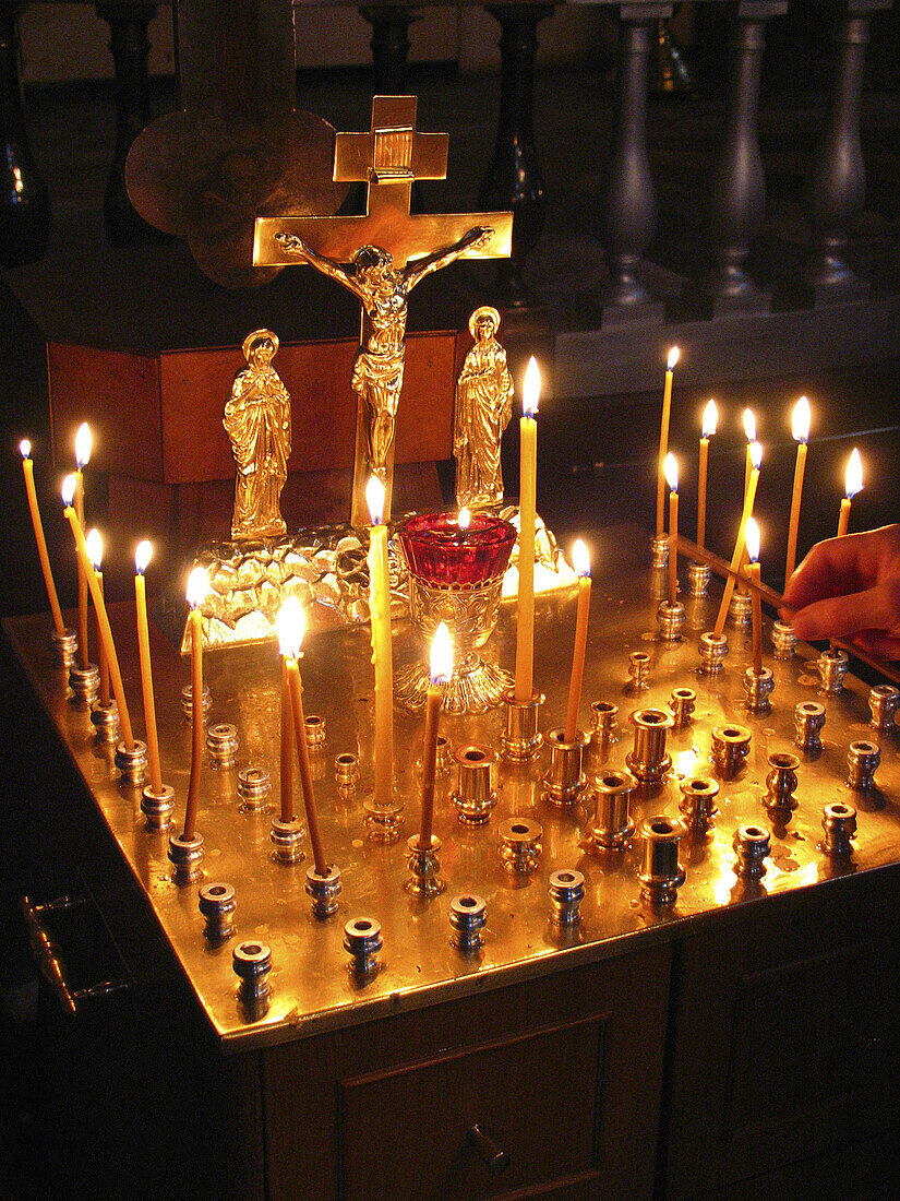 Candles lit Orthodox cross in Church of the Bleeding Savior, Russian revival style architecture. St. Petersburg. Russia
