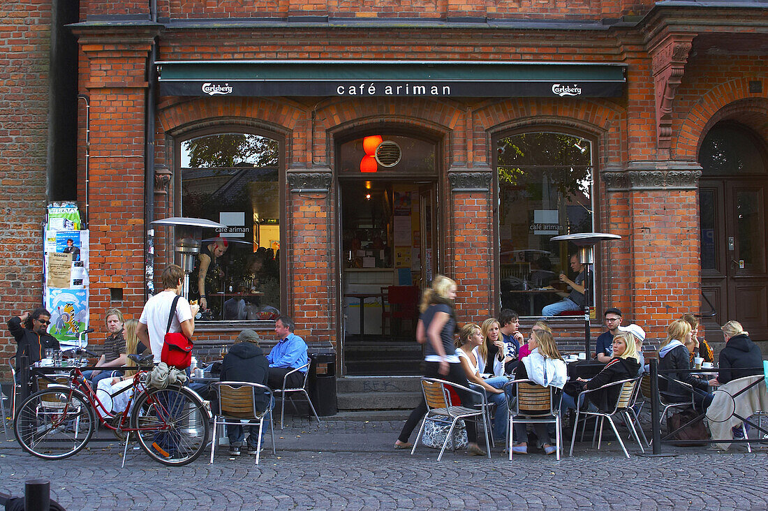 Young people sitting in sidewalk cafe, Lund, Sweden
