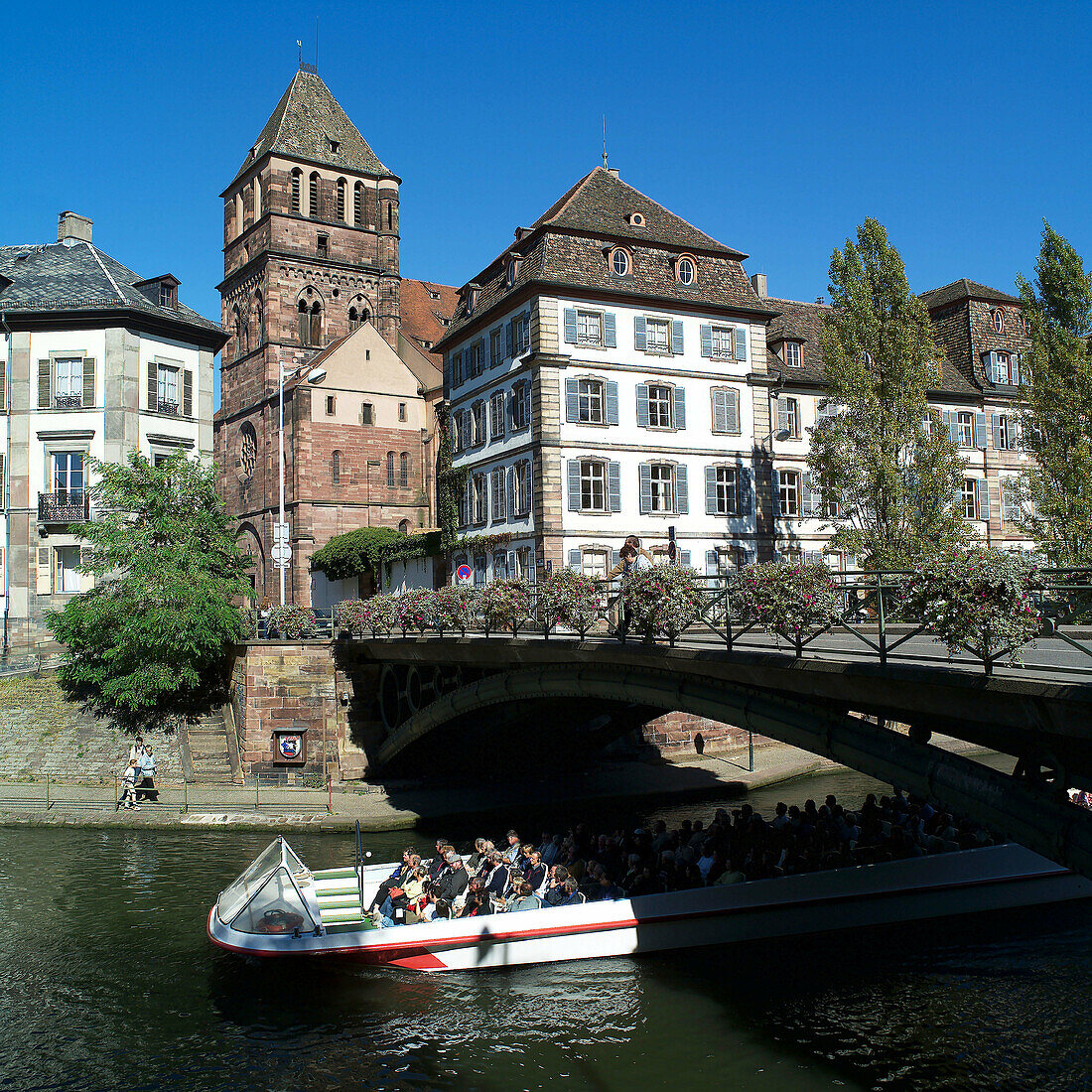 Sightseeing boat and St. Thomas church in background. Strasbourg. France