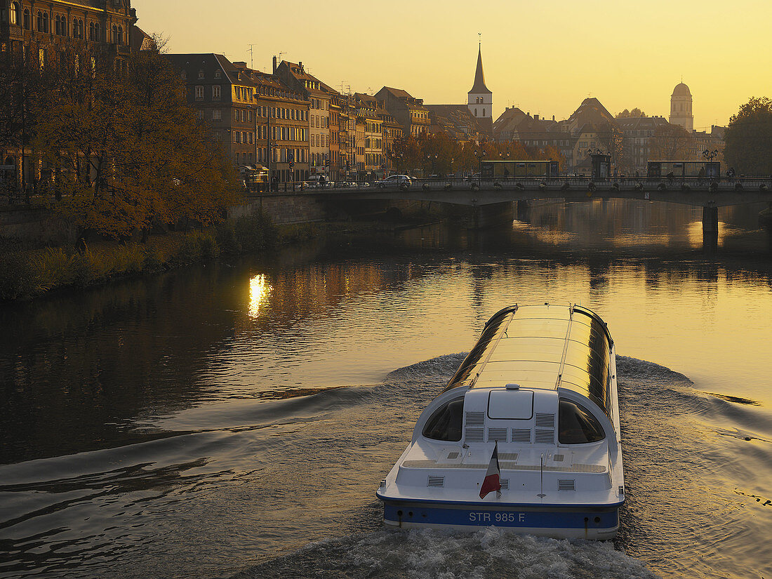 Tourist boat on Ill river at sunset. Strasbourg. Alsace. France.