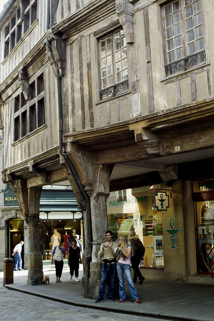 Couple of young tourists and half-timbered houses. Dinan. Britanny. France.