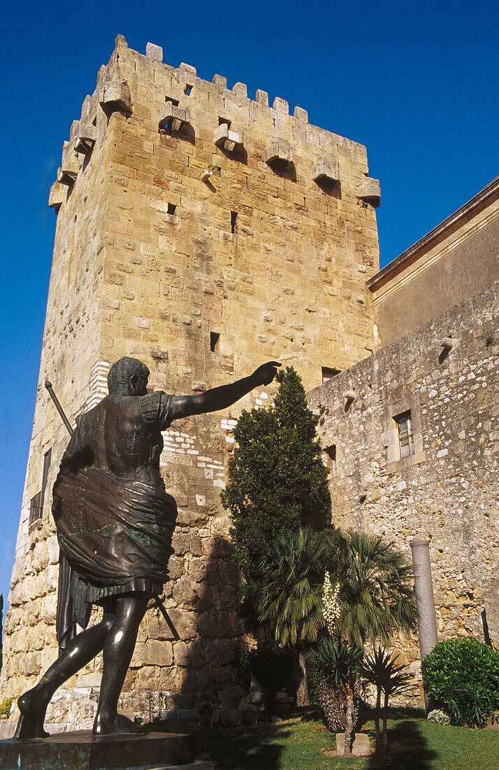 Caesar Augustus statue next to the ramparts and Torre de l Arquebisbe. Passeig Arqueologic. Tarragona. Catalonia. Spain