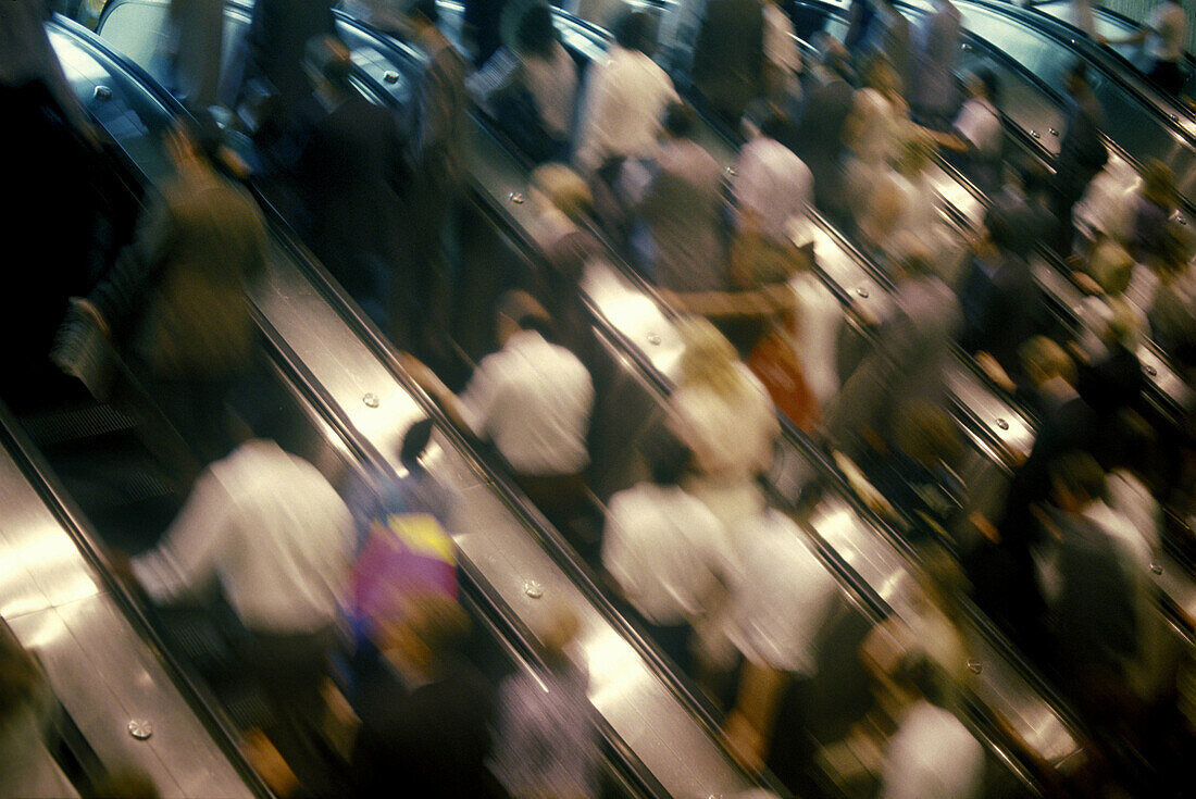 Crowd: commuters on escalators.