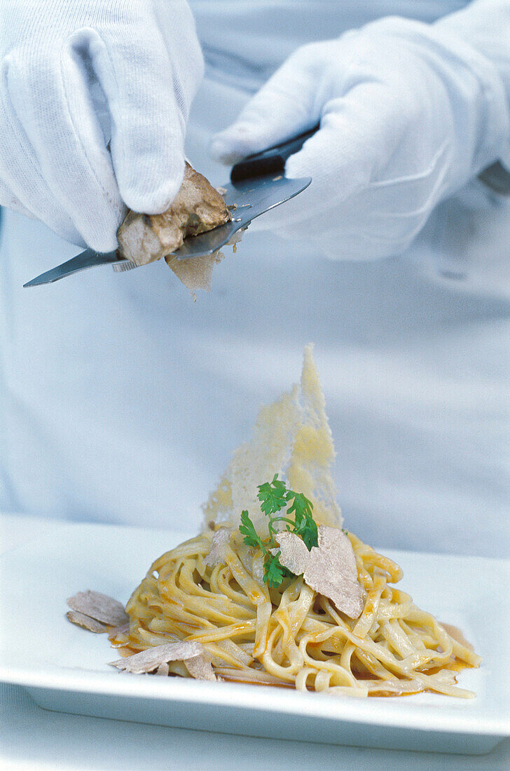 Chef putting white truffles to a dish of tagliolini. Hotel de Russie. Rome. Italy