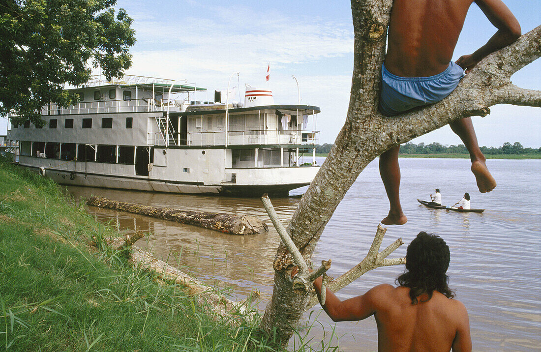 Men watching the river traffic. The Amazon river. Leticia, Amazon. Colombia