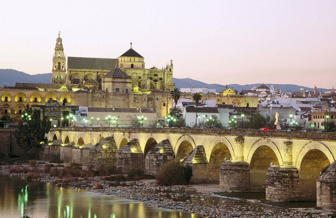 Puente Romano spanning the Guadalquivir River and the Merzquita at dusk. Córdoba. Andalusia. Spain