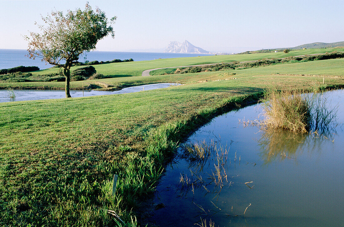 Golf course of Alcaidesa housing development, Mediterranean coast and Rock of Gibraltar in background. Cádiz province, Andalusia, Spain