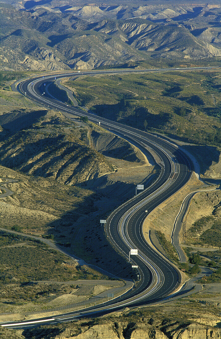 The A 92 motorway from Granada to Almería cuts through the dramatic landscape of bare, eroded sandstone of the Tabernas Desert, Europe s only true desert. Province of Almería, Andalucía, Spain.