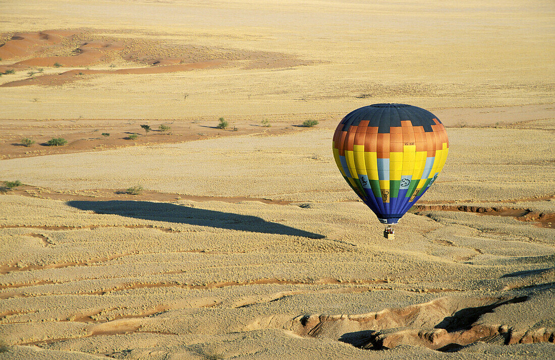 The hot-air balloon above eroded landscape at the edge of the Namib Desert. Namib-Naukluft Park, Namibia.