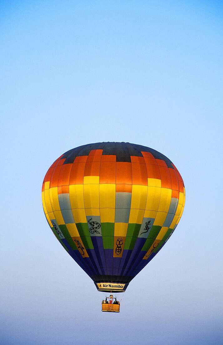 The hot-air balloon shortly after take-off in the light of the early morning. Namib Desert, Namib-Naukluft Park, Namibia.