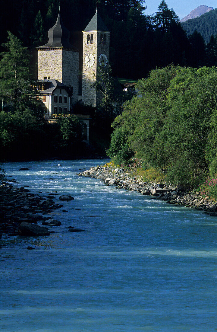 river Inn (En) with houses and spire of Susch, Engadin, Grisons, Switzerland