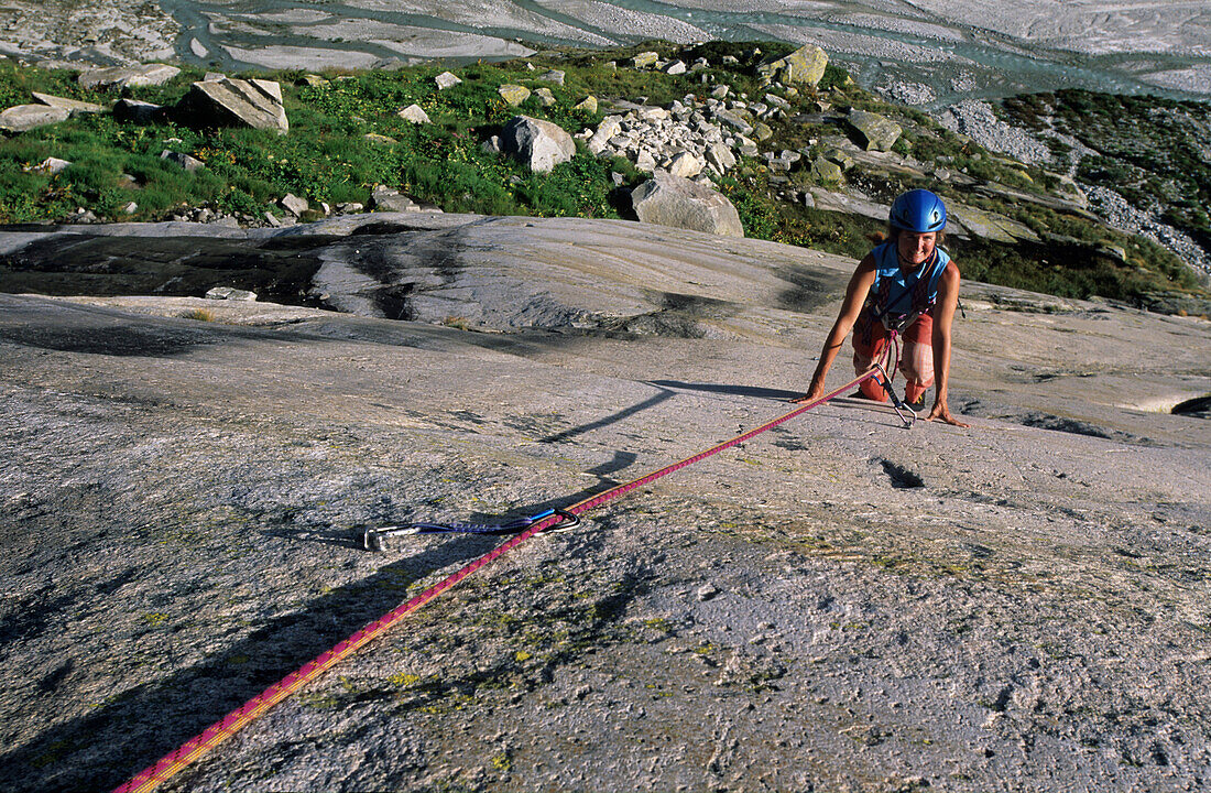 Frau klettert an Granitplatten, Bächlital, Grimselpass, Berner Oberland, Schweiz
