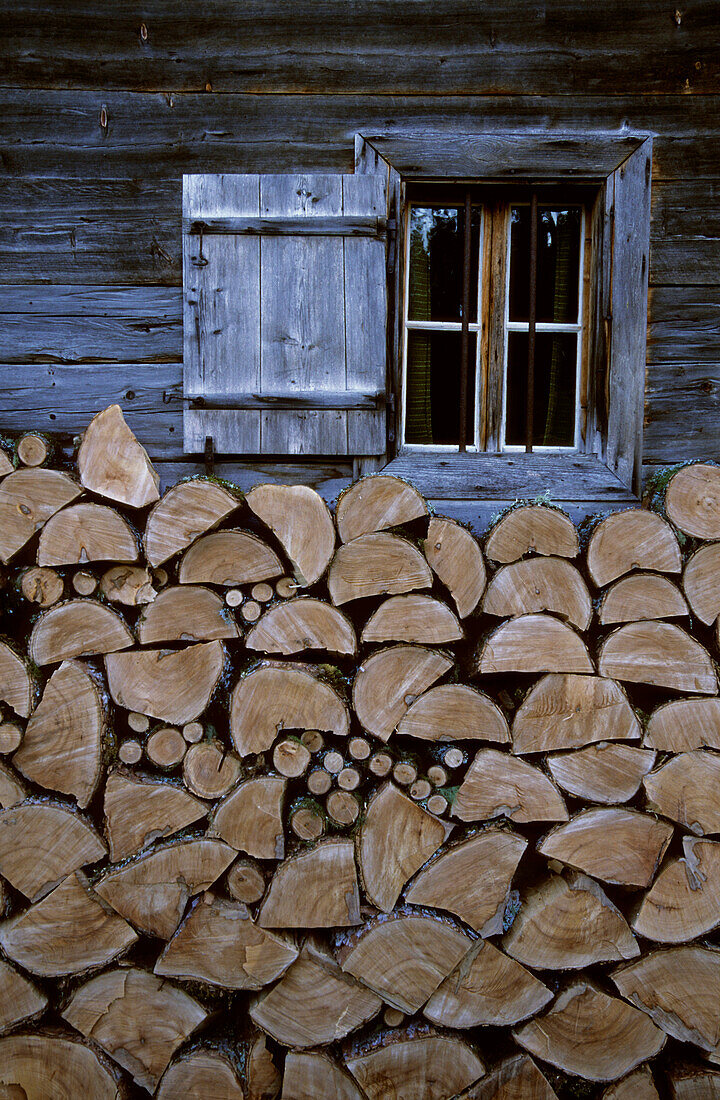 Holzscheite vor dem Fenster einer Berghütte, Wilder Kaiser, Kaisergebirge, Tirol, Österreich