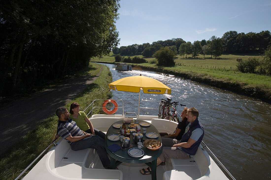 Menschen beim Frühstück auf Crown Blue Line Calypso Hausboot am Canal de la Marne au Rhin, nahe Heming, Elsass, Frankreich, Europa