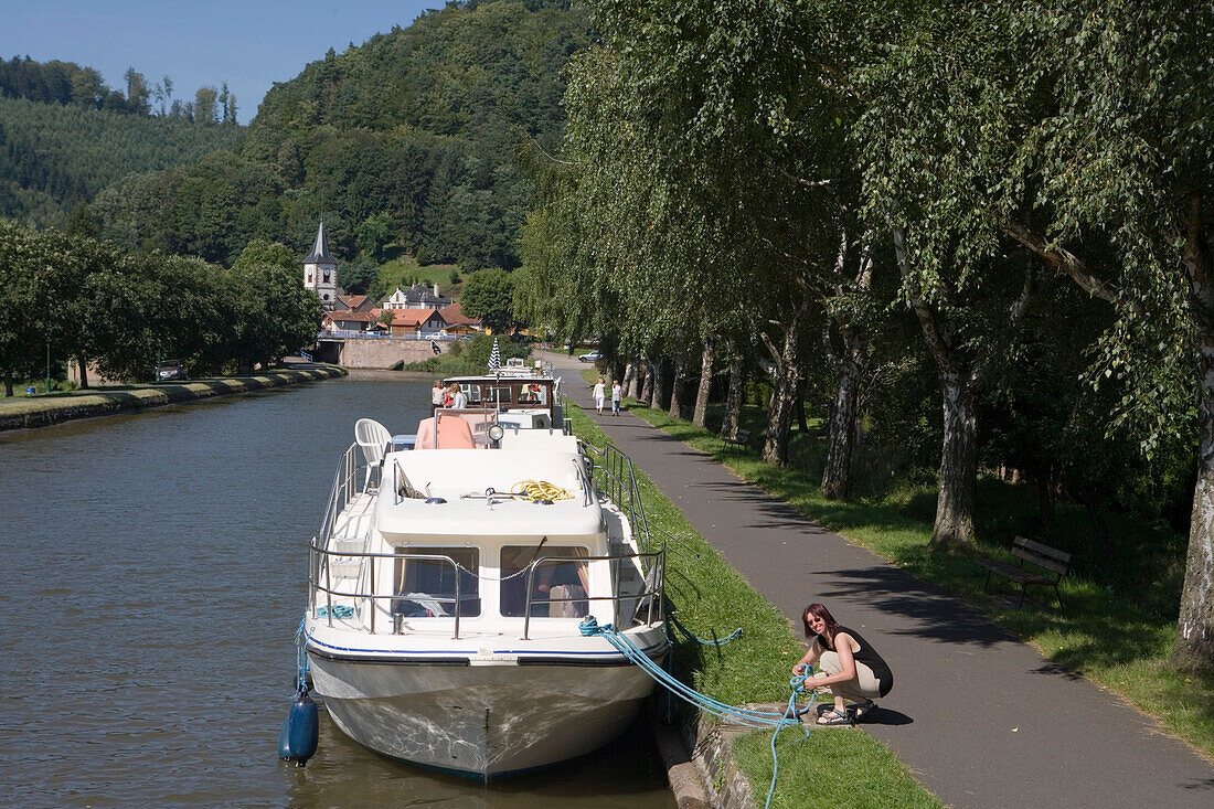 Frau legt Leinen los an Crown Blue Line Calypso Hausboot am Canal de la Marne au Rhin, Lutzelbourg, Elsass, Frankreich, Europa