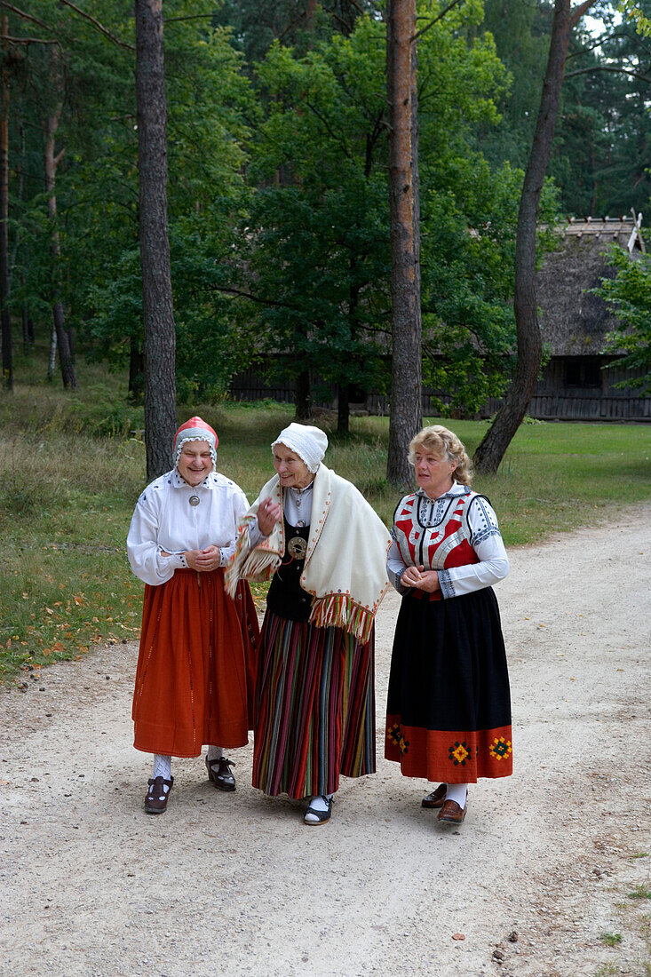Three ladies in traditional costumes in the farm house museum of Latvia