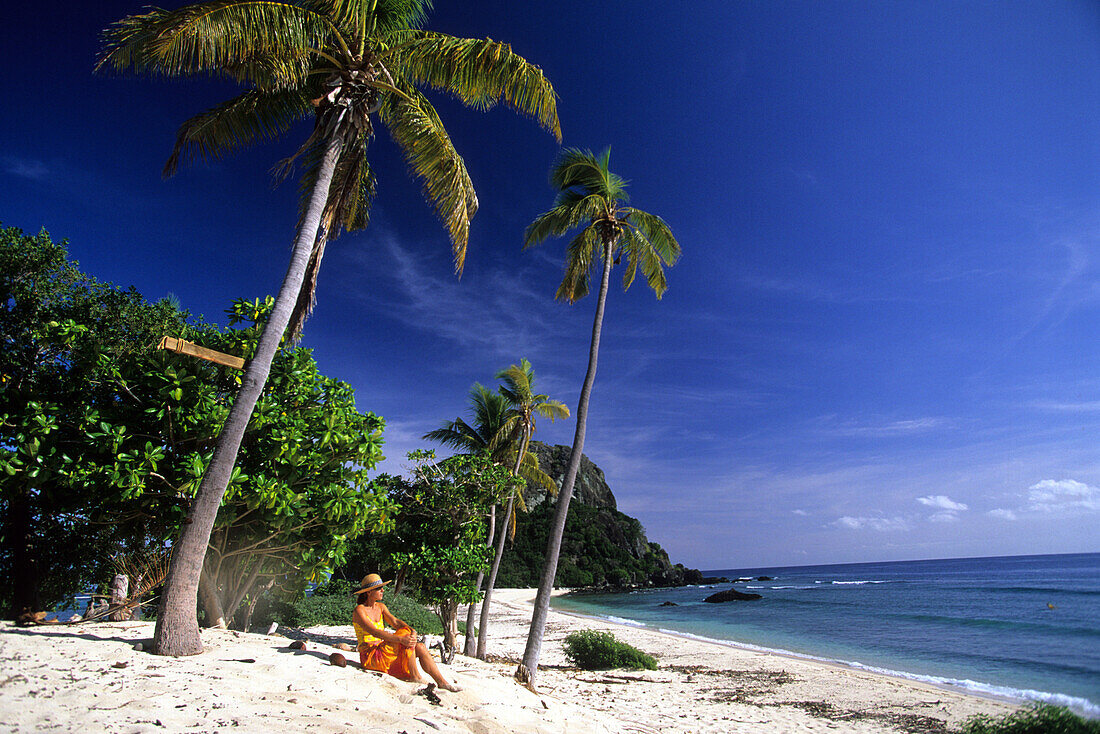 Woman sitting on the beach at Navadra Island, Mamanuca group, Fiji, South Sea