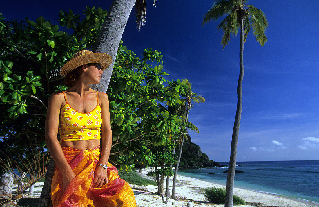 Woman on a sandy beach looking out to sea, Navadra Island, Mamanuca group, Fiji, South Sea