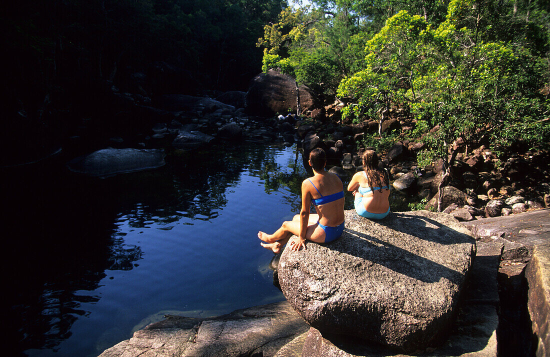 Zwei Mädchen beim Rasten an den Mulligan Falls, Hinchinbrook Island, Great Barrier Reef, Australien