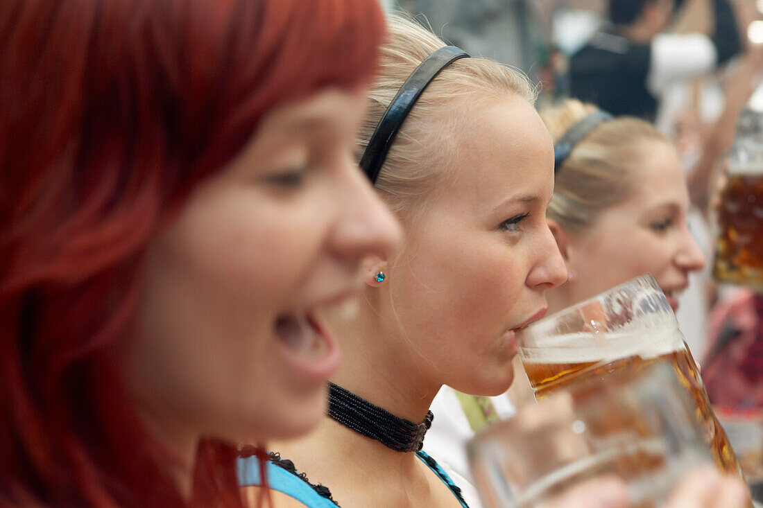 Drei junge Frauen amüsieren sich auf dem Oktoberfest, München, Bayern, Deutschland