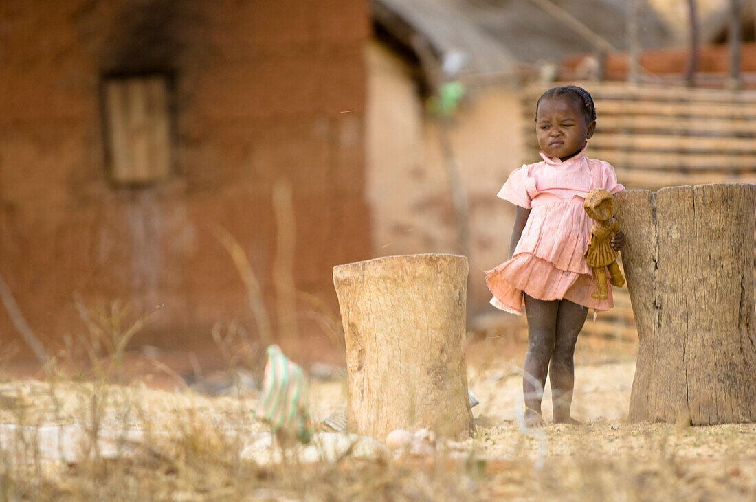 Small child, girl in a village holding a doll, Madagaskar