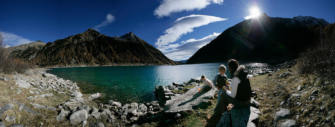 Family at shore of the Neves reservoir in Muhlwald valley, Selva dei Molini near Bruneck, Trentino-Alto Adige/Südtirol, Italy