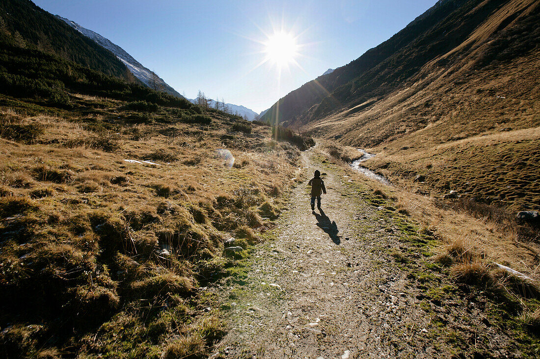 Kind läuft auf Weg im Knuttenbachtal, bei Bruneck, Trentino-Südtirol, Italien
