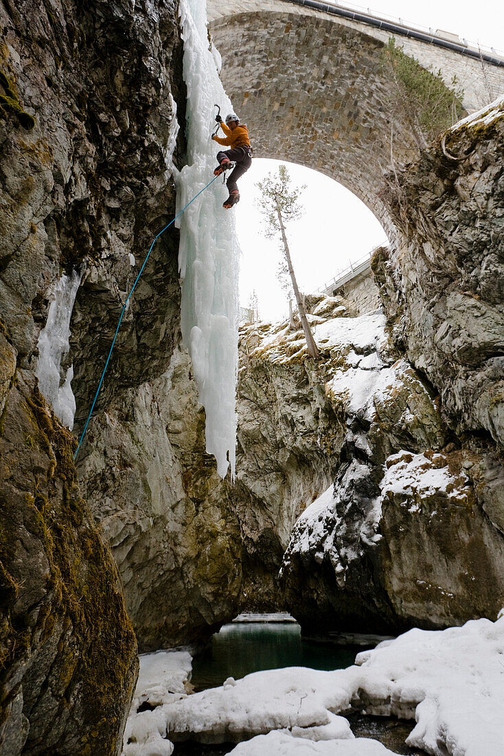 Mann beim Eisklettern in einer Schlucht, Pontresina, Oberengadin, Graubünden, Schweiz