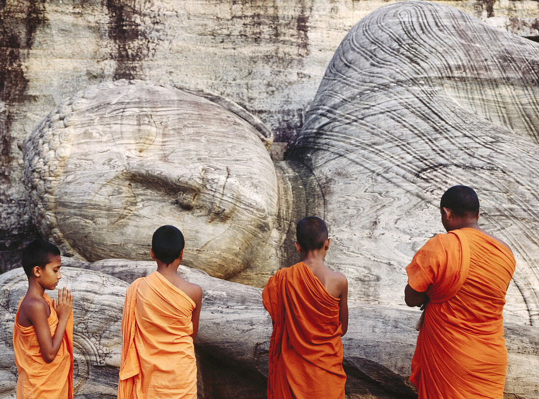 Monks praying at dawn in Gal Vihara temple, Polonnaruwa. Sri Lanka