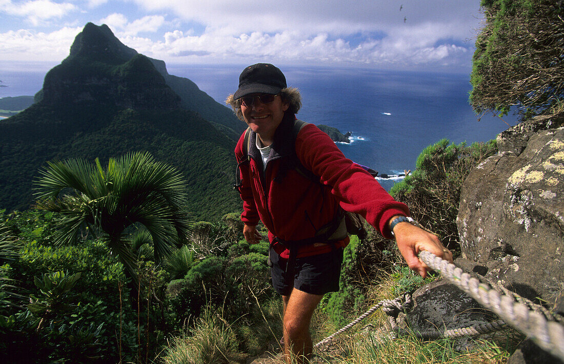 Man climbing onto Mt. Gower, Lord Howe Island, Australia