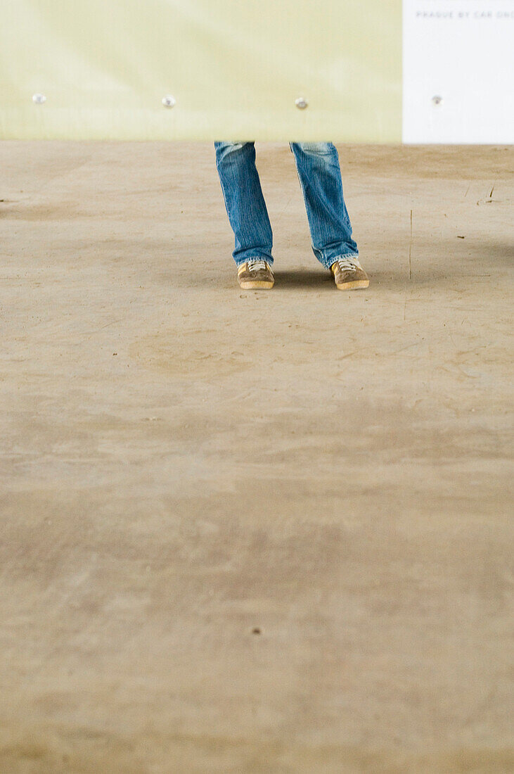 Person standing behind a billboard