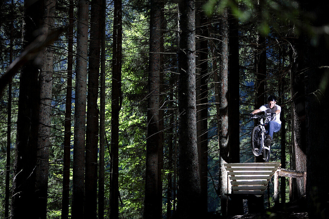Junger Mann fährt Mountainbike im Wald, Oberammergau, Bayern, Deutschland