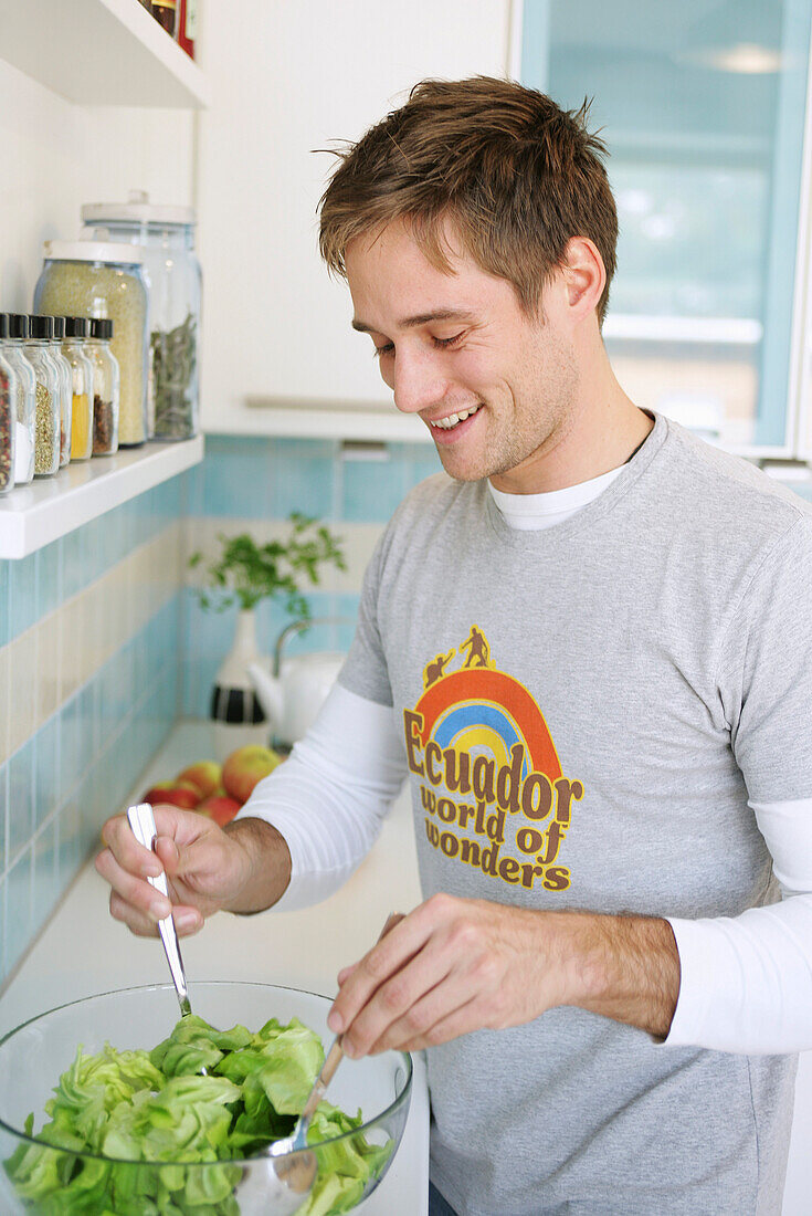 Young man preparing a salad, Munich, Germany