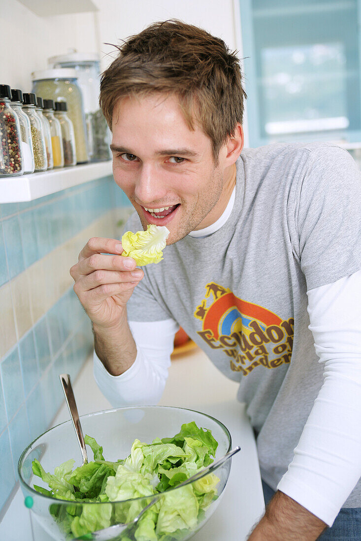 Young man tasting a salad, Munich, Germany