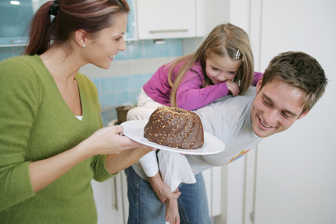 Young family with a chocolate cake in a domestic kitchen, Munich, Germany