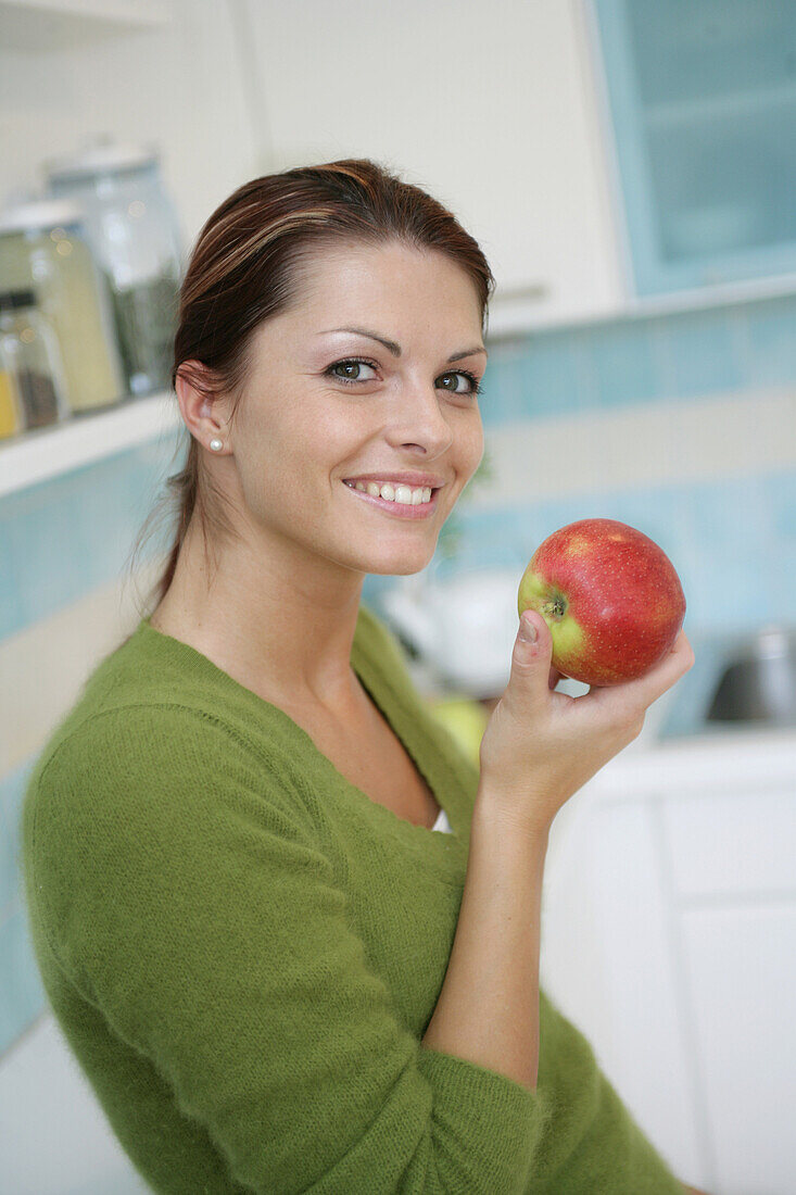 Young woman eating an apple, Munich, Germany
